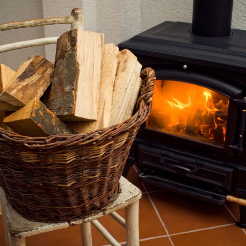 Basket of logs in front a burning fire