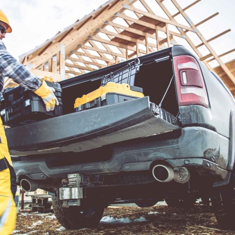 A worker unloading tools from a truck at a construction site