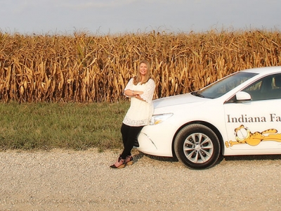 Woman leaning against car